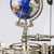 Detail des Uhrwerks mit Messingzahnrad, Metallstangen und Globusaufsatz in Blau
