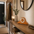 Horloge de table en bois sur commode en bois, boîtier marron avec cadran rond.