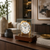 Horloge de table dans un boîtier en verre avec cadran blanc, éléments en laiton et socle en noyer