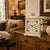 Horloge de table blanche sur commode en bois avec chiffres romains et cadre floral