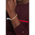Bracelet jaseron doré au poignet avec plaque logo