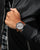 Herrenarmbanduhr mit grauem Zifferblatt und braunem Lederarmband, Krone sichtbar