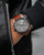Herrenarmbanduhr: rundes graues Zifferblatt, braunes Lederarmband, analoges Quarzwerk