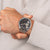 Armbanduhr für Herren: silbernes Meshband, schwarzes Zifferblatt mit Chrono-Anzeigen