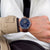 Herrenarmbanduhr am Handgelenk, blaues Zifferblatt, braunes Lederband.