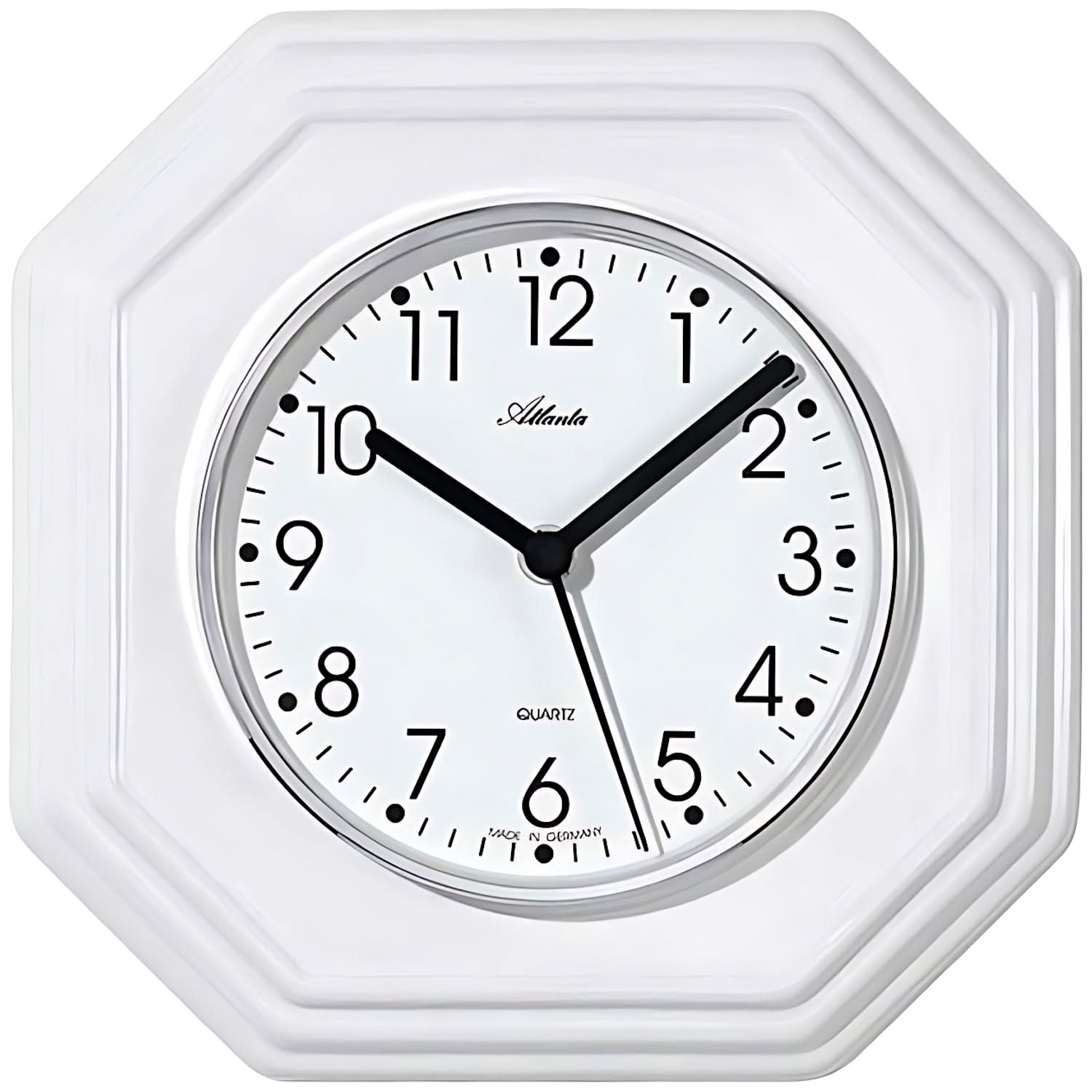 Weiße Wanduhr mit achteckigem Keramikrahmen, rundem Zifferblatt mit schwarzen Zeigern.