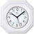 Weiße Wanduhr mit achteckigem Keramikrahmen, rundem Zifferblatt mit schwarzen Zeigern.