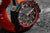 Montre homme avec boîtier noir, lunette rouge et rehaut orange