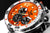 Montre homme avec cadran orange, compteurs chronographes noirs et lunette argentée