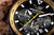 Herren-Solarchronograph: schwarzes Zifferblatt mit gelber Chrono-Sekunde und goldener Lünette