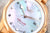 Détail de montre pour femme : cadran argenté avec aspect diamant, aiguilles et date à 12h