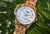 Montre pour femme avec bracelet en acier inoxydable doré et cadran bleu, boutons-poussoirs visibles sur le côté.