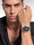 Herrenarmbanduhr am Handgelenk mit silbernem Metallband und schwarzem Zifferblatt