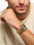 Herrenarmbanduhr am Handgelenk: goldfarbenes Metallarmband und schwarzes Zifferblatt