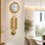 Horloge murale en laiton avec pendule dorée et boîtier rond au-dessus d'un salon
