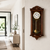 Horloge murale marron en bois sur le mur avec un cadran rond et une cloche dorée