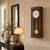 Horloge murale en bois avec cadran rond et pendule dans un boîtier mural étroit