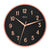 Horloge murale ronde avec cadran noir, bordure or rose et chiffres romains
