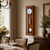 Horloge murale en merisier avec façade en verre, cadran rond et pendule oscillante