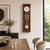 Horloge murale en bois marron sur le mur avec cadran blanc, barres de gong dorées