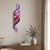 Horloge murale sur un mur avec un motif ondulé coloré, un pendule violet et des chiffres blancs