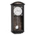 Horloge murale avec boîtier en bois foncé, cadran blanc et chiffres romains, pendule visible