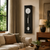 Horloge murale avec boîtier noir, balancier rond et cadran blanc dans le salon.