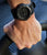 Montre bracelet pour homme au poignet avec cadran noir et bracelet en caoutchouc noir