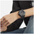 Montre pour homme au poignet avec bracelet noir et chiffres lumineux sur le cadran.