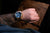 Montre homme au poignet avec cadran bleu et bracelet en cuir marron