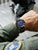 Am Handgelenk getragene Zeppelin Herrenuhr mit blauem Zifferblatt und schwarzem Lederarmband