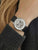 Damen Armbanduhr am Handgelenk mit schwarzem Lederarmband und offenem Mechanikzifferblatt