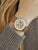 Damenarmbanduhr am Handgelenk: beiges Lederband, Skelett-Automatik, silbernes Gehäuse, goldene Details