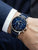 Herrenchronograph am Handgelenk: blaues Zifferblatt, Edelstahlgehäuse, dunkelblaues Lederband