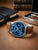 Herrenuhr mit blauem Zifferblatt und braunem Lederarmband, silbernes Stahlgehäuse