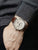 Herrenuhr am Handgelenk: braunes Lederarmband, helles Zifferblatt mit Chrono-Subdials