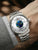 Herrenuhr am Handgelenk, silbernes Edelstahlband, weißes Zifferblatt mit blauem Motiv