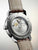 Rückseite der Herrenuhr mit silbernem Gehäuse und braunem Lederarmband