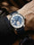 Herrenautomatik-Uhr am Handgelenk mit blauem Zifferblatt und dunkelblauem Lederarmband