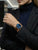 Damenuhr am Handgelenk mit blauem Zifferblatt und braunem Lederarmband