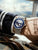 Herrenarmbanduhr am Handgelenk mit blauem Zifferblatt und silbernem Mesh-Armband