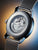 Rückseite einer Herrenarmbanduhr mit silbernem Gehäuse und Edelstahl-Meshband
