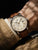 Zeppelin Herrenarmbanduhr am Handgelenk mit braunem Lederband und beigem Zifferblatt