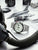 Herrenuhr mit weißem Zifferblatt und Edelstahlband auf Modellflugzeug-Details