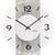 Nahaufnahme Wanduhr: weißer Kreis mit schwarzen Zahlen, Betonstruktur, AMS-Logo