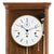 Gros plan d'une horloge murale en bois : cadran blanc avec chiffres romains et bordure dorée